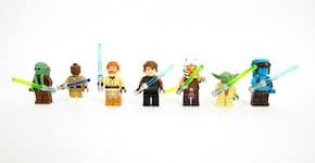 Seven Lego Star Wars mini-figures, all wielding lightsabers.