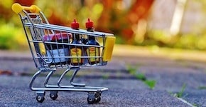 A miniature shopping cart filled with small bottles of condiments, specifically "Würze" brand seasoning